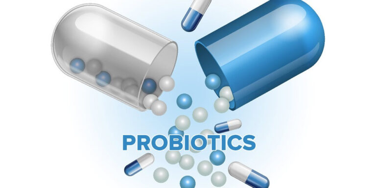 a digital illustration of a blue and white capsule split open, with white and blue spheres and smaller capsules spilling out. the word probiotics appears in blue capital letters below the capsule. uk