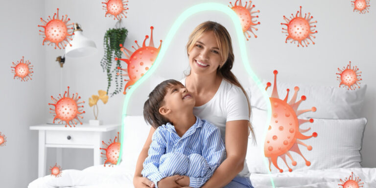 a smiling woman and child sit on a bed, surrounded by illustrated virus particles. a glowing outline surrounds them, suggesting protection from the viruses. the room is bright and minimally decorated. uk